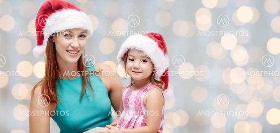happy mother and little girl in santa hats