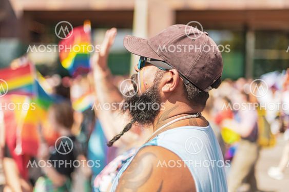 Man with beard and cap from the side at the pride parade...