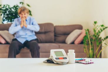 An old woman measures her blood pressure. Selective focus.