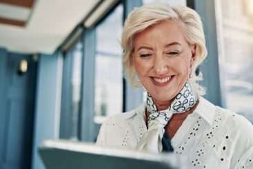 Tablet, happy and mature businesswoman in office reading...