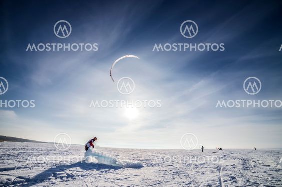 Kiteboarder with blue kite on the snow