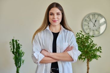 Confident young woman with crossed arms in home interior