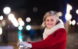 Senior woman on a walk in night city. Winter