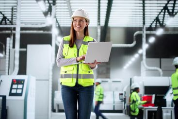 Female technician supervising automated production line