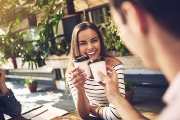 Woman, joy and cheers with coffee cup in cafe as...