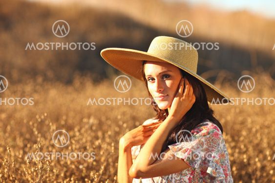 Young Beautiful Woman on a Field in Summer Time