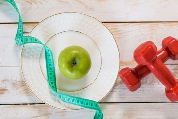 Fitness concept with dumbbells and measuring tape