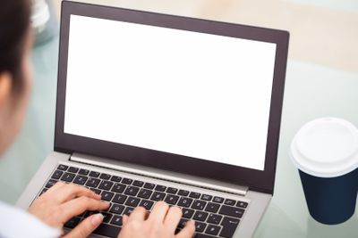 Businesswoman Working On Laptop With Disposable Cup
