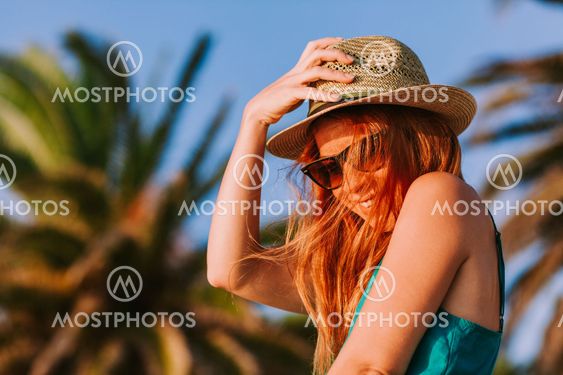 Young woman enjoying the view by the palm trees