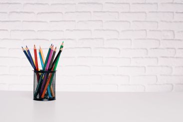 Colorful pencils arranged in a holder on a clean desk...