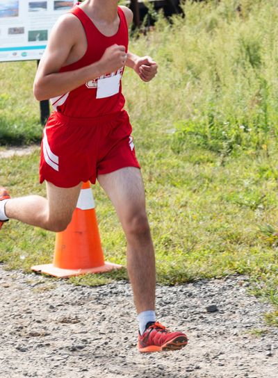 Male cross country runner racing on dirt path