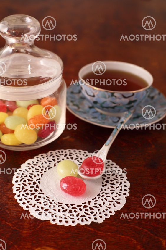 Tea with coloured sugar candies in a glass can