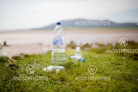 Couple of Littered Plastic Bottles on Grass with a...