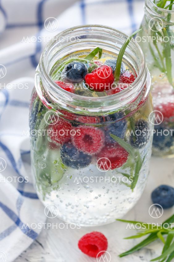 Ice sparkling water, berries and tarragon in jar.