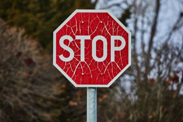 Stop sign with broken paint peeling