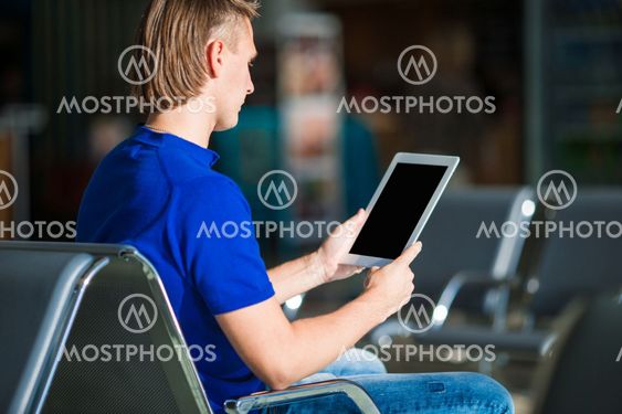 Young man with laptop at the airport while waiting for...