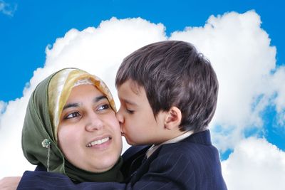 Muslim woman kissing her son