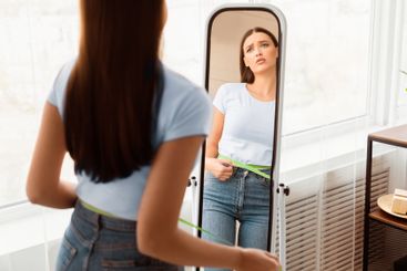 Frustrated Lady Measuring Waist Gaining Weight Standing...