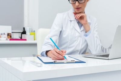 female doctor writing in clipboard