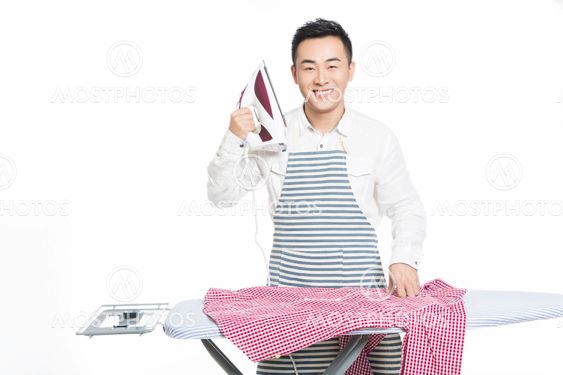 chinese young man ironing his clothes