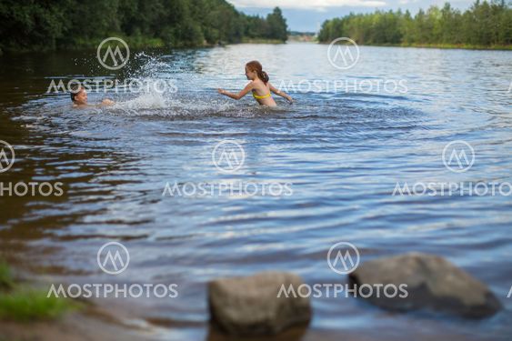 Two naughty girls bathe in the lake.