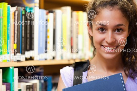 Happy female student holding a book
