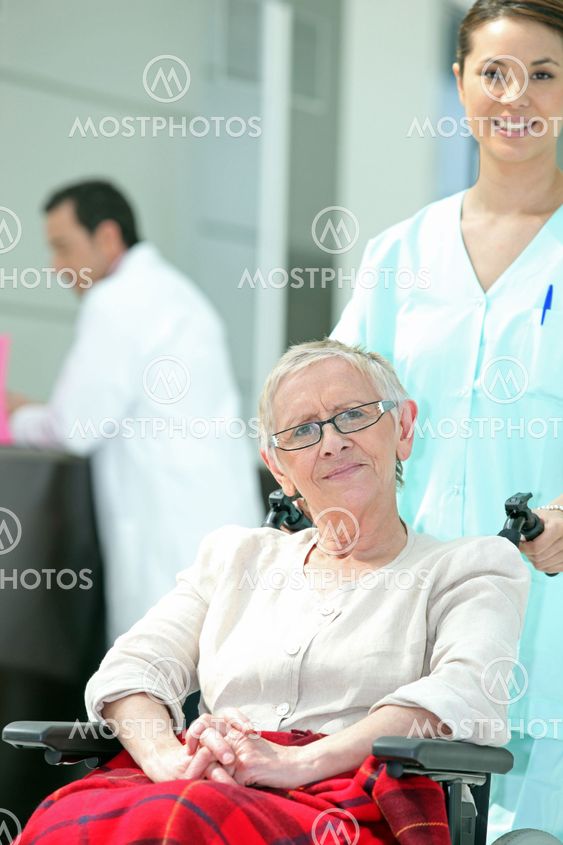 Senior woman in wheelchair with young nurse