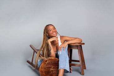 Beautiful brunette woman with braids in her hair sitting...