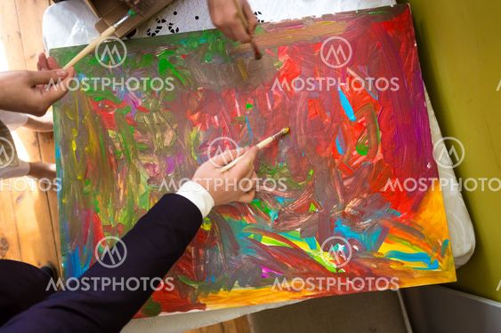 Closeup of people mixing colorful paints on canvas