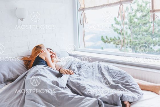 Young couple enjoying bed time in the morning