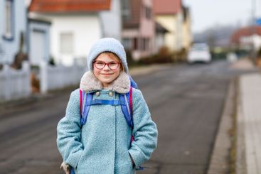 Cute little girl o the way to or from school. Healthy...