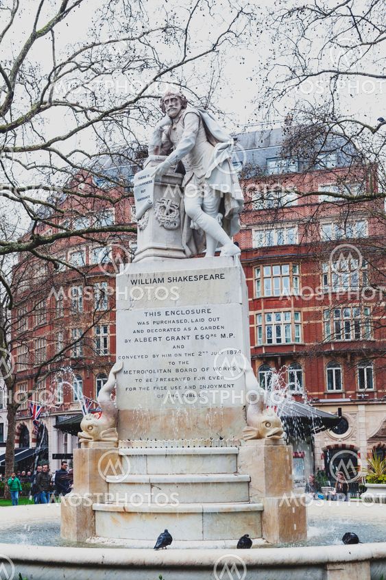 London, UK - April 2018: The Shakespeare fountain and marble statue of William Shakespeare surrounded by dolphins, sculpted by Giovanni Fontana, located at small park in Leicester Square Gardens in City of Westminster, London, United Kingdom