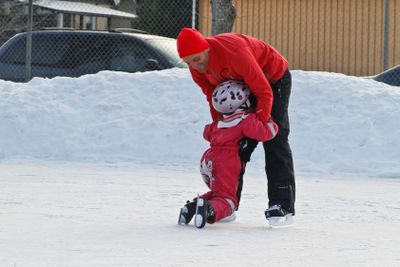 Förälder med flicka på isbana 3