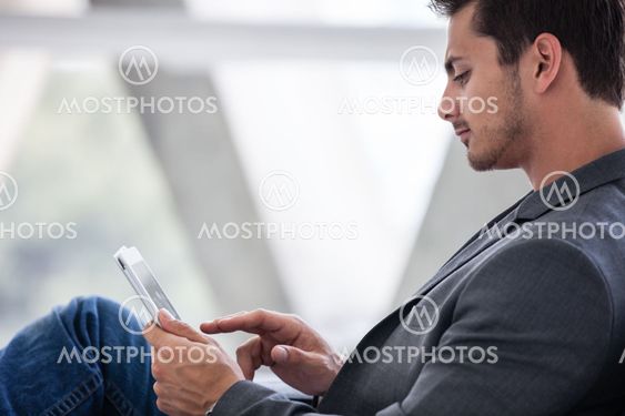 Attractive man in his 20s working on a mini think pad