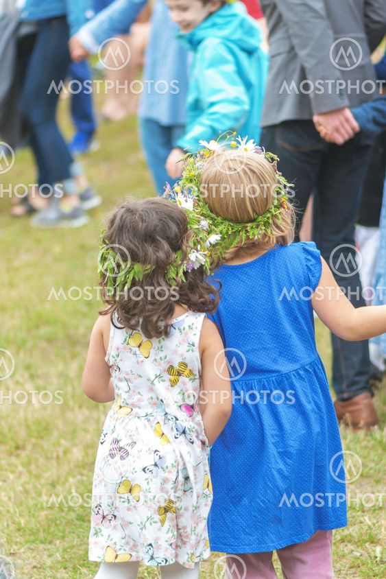 People celebrating midsummer with dance around the maypole