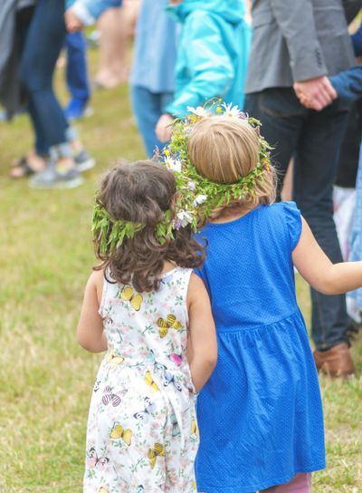 People celebrating midsummer with dance around the maypole