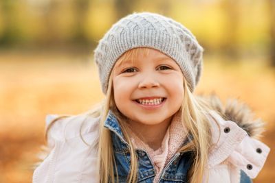 portrait of happy little girl at autumn park