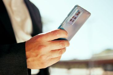 City, cellphone and hands of person typing for...