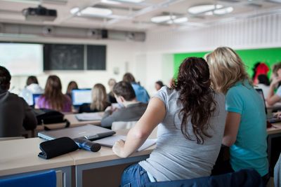 young pretty female college student sitting in a classroom