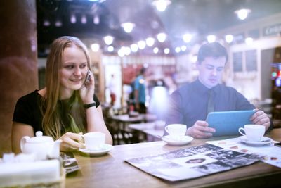 Woman on cellphone drinking coffee