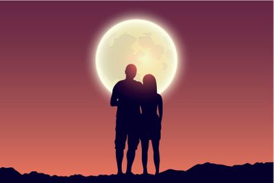 young couple looks to the full moon silhouette