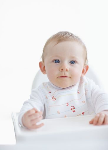Baby boy, portrait and high chair in studio, relax and...