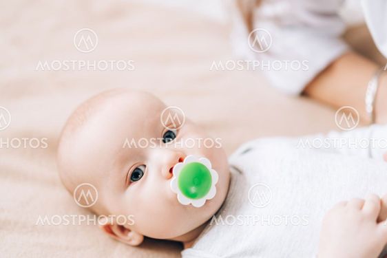 Small child has nipple in its mouth. Love and care for...