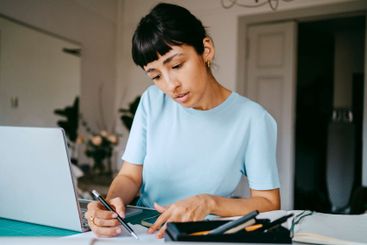 Female business professional planning strategy at desk...