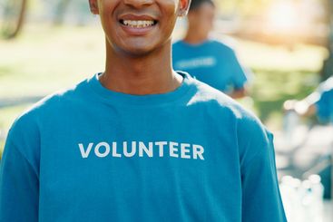 Volunteer, smile and helping with man in park for...