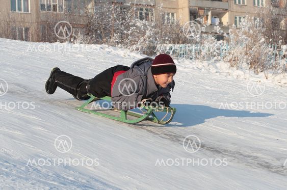happy asian boy on sledge