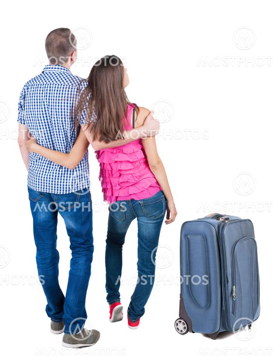 Back view of young couple traveling with suitcas .
