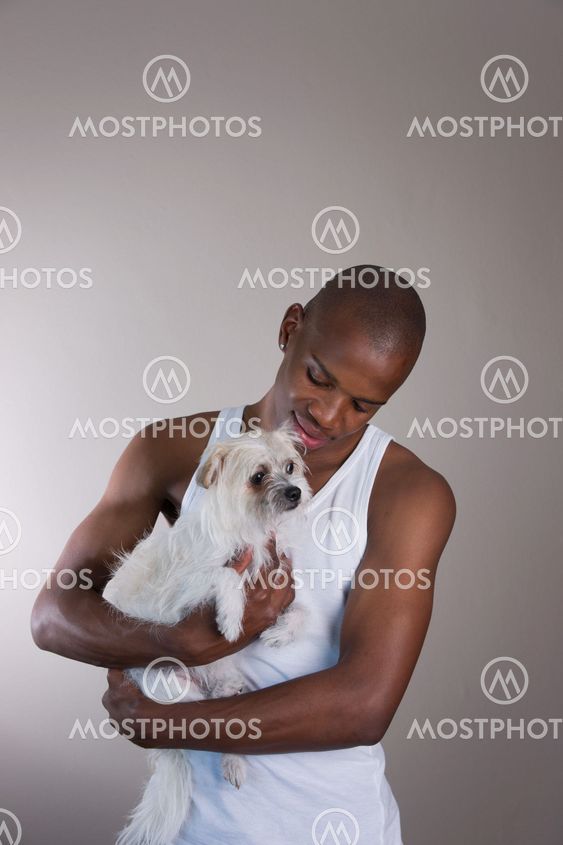 Little white dog with its African owner