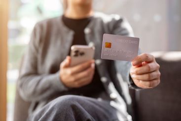 A close-up of a woman sits indoors on a bright day,...