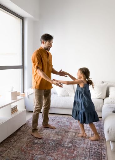 Loving dad and little daughter dancing at home